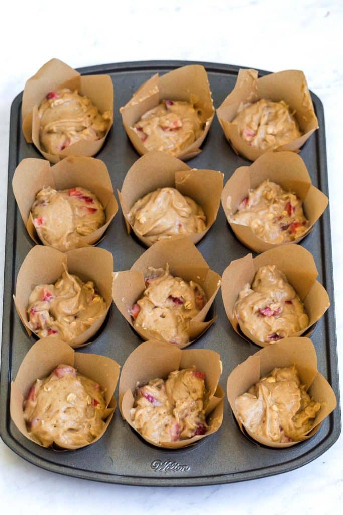 image of paper lines in a muffin tin, strawberry muffin batter inside of each cup