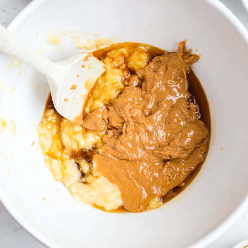mashed banana, peanut butter, and vanilla in a white bowl. 