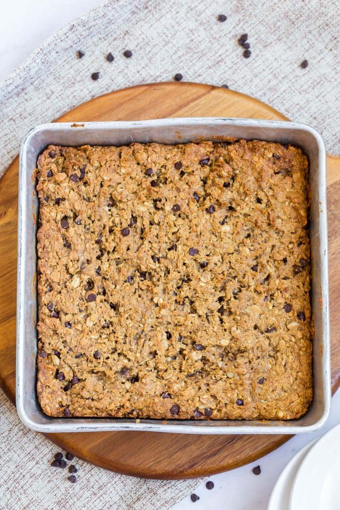 cooked recipe in a steel square pan with a wood trivet underneath