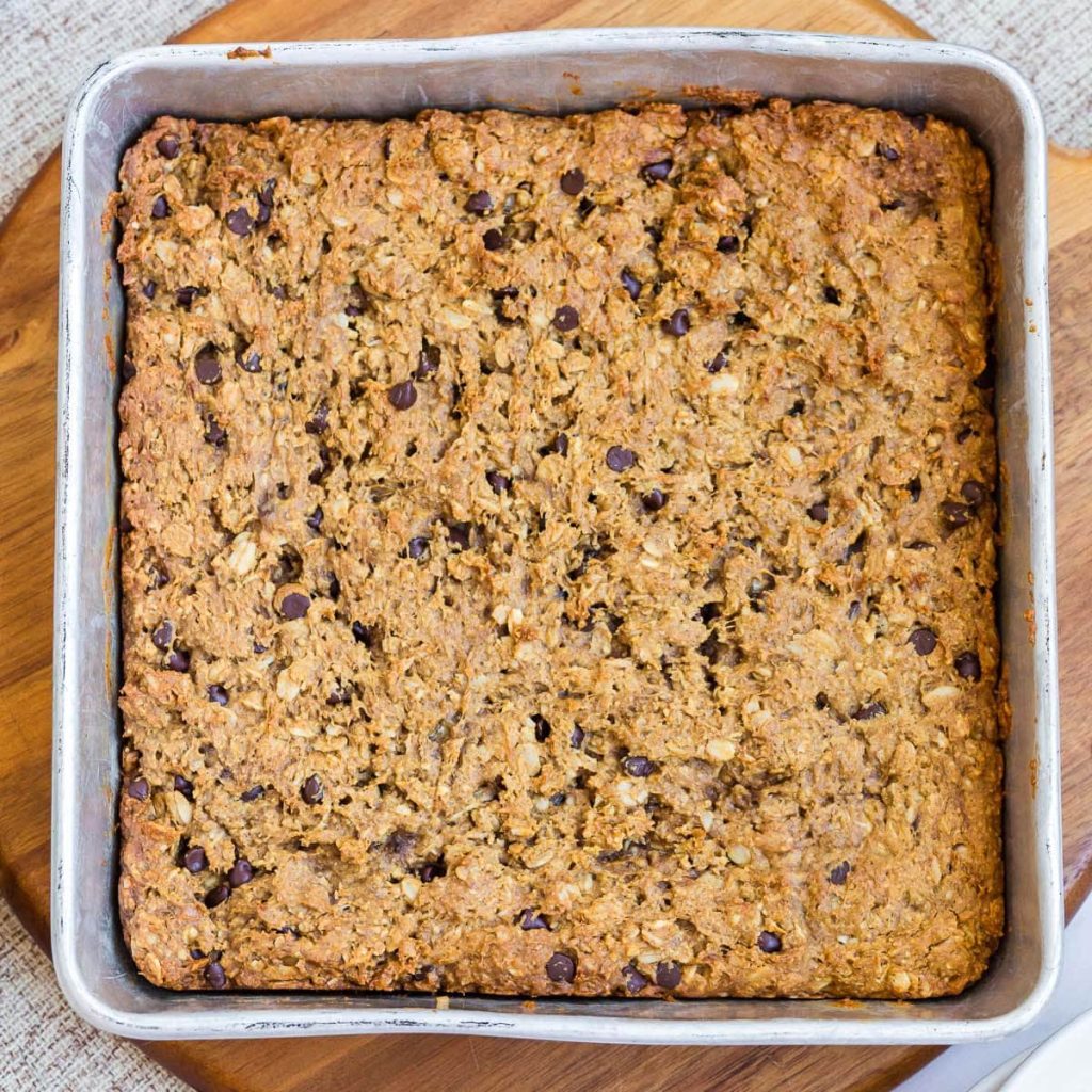 Cooked recipe in a steel square pan with a wood trivet underneath.