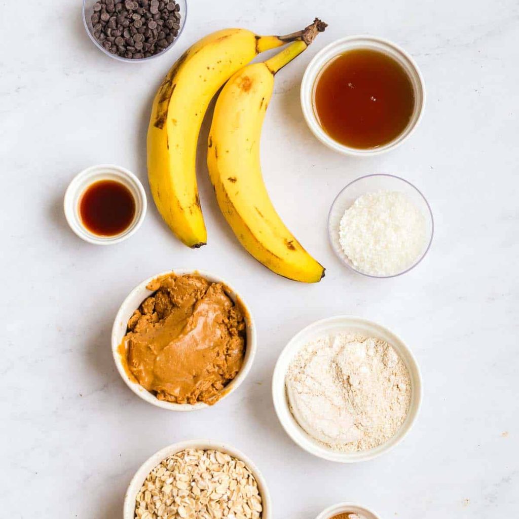 ingredients for this recipe on a white counter: 2 bananas, 8 white and clear bowls with ingredients.