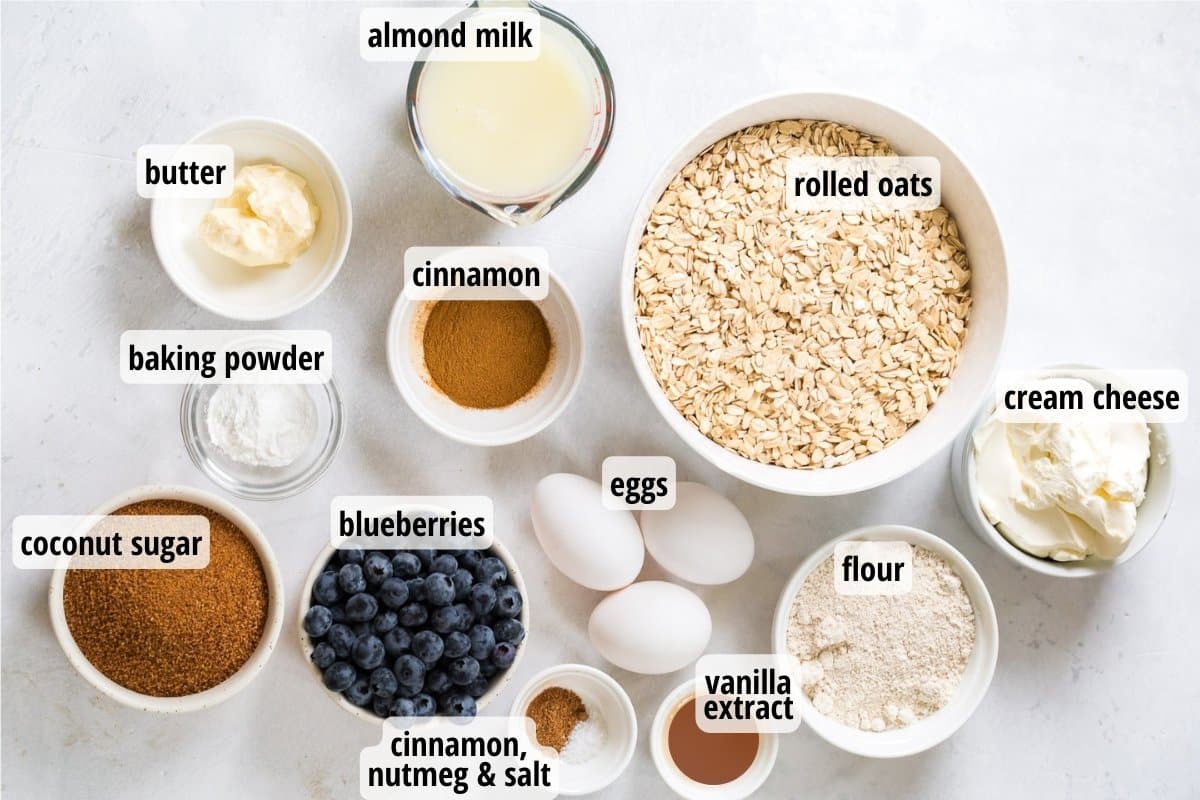 Labeled ingredients on a white counter top needed to make Blueberry Oatmeal Bake.