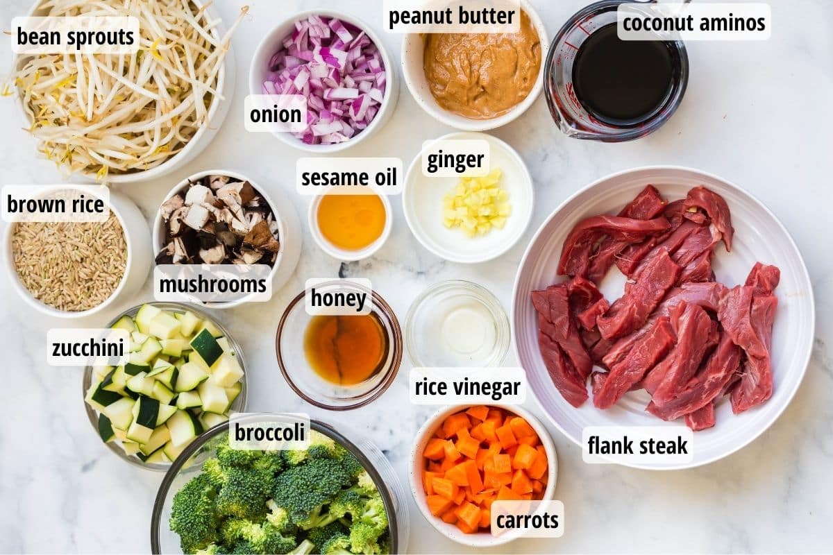Labeled ingredients in white and glass bowls on top of a white counter top.