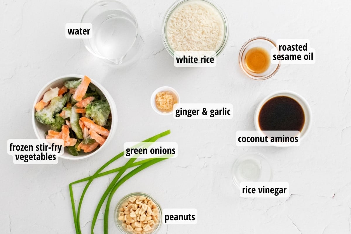 A white counter top with labeled ingredients needed to make Instant Pot Veggie Fried Rice.