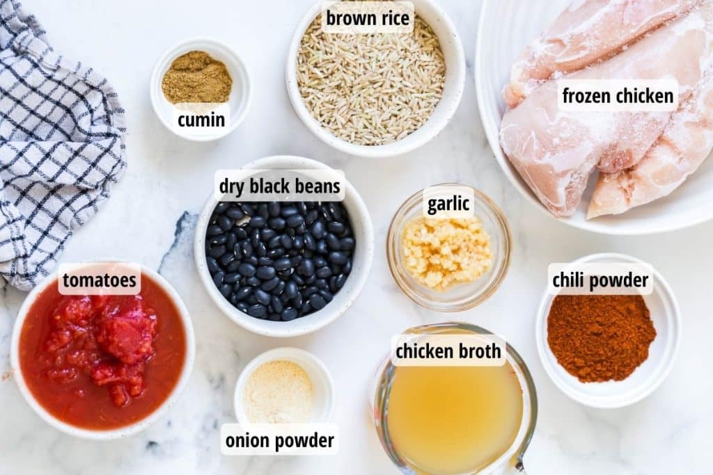 labeled ingredients in white and glass bowls on top of a white marble counter top.