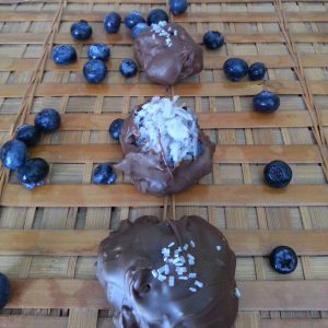 Wood counter with blueberry coconut bonbons and blueberries in the background.
