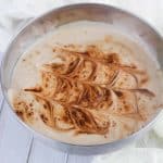 Silver bowl with decorated mocha flavored yogurt inside.